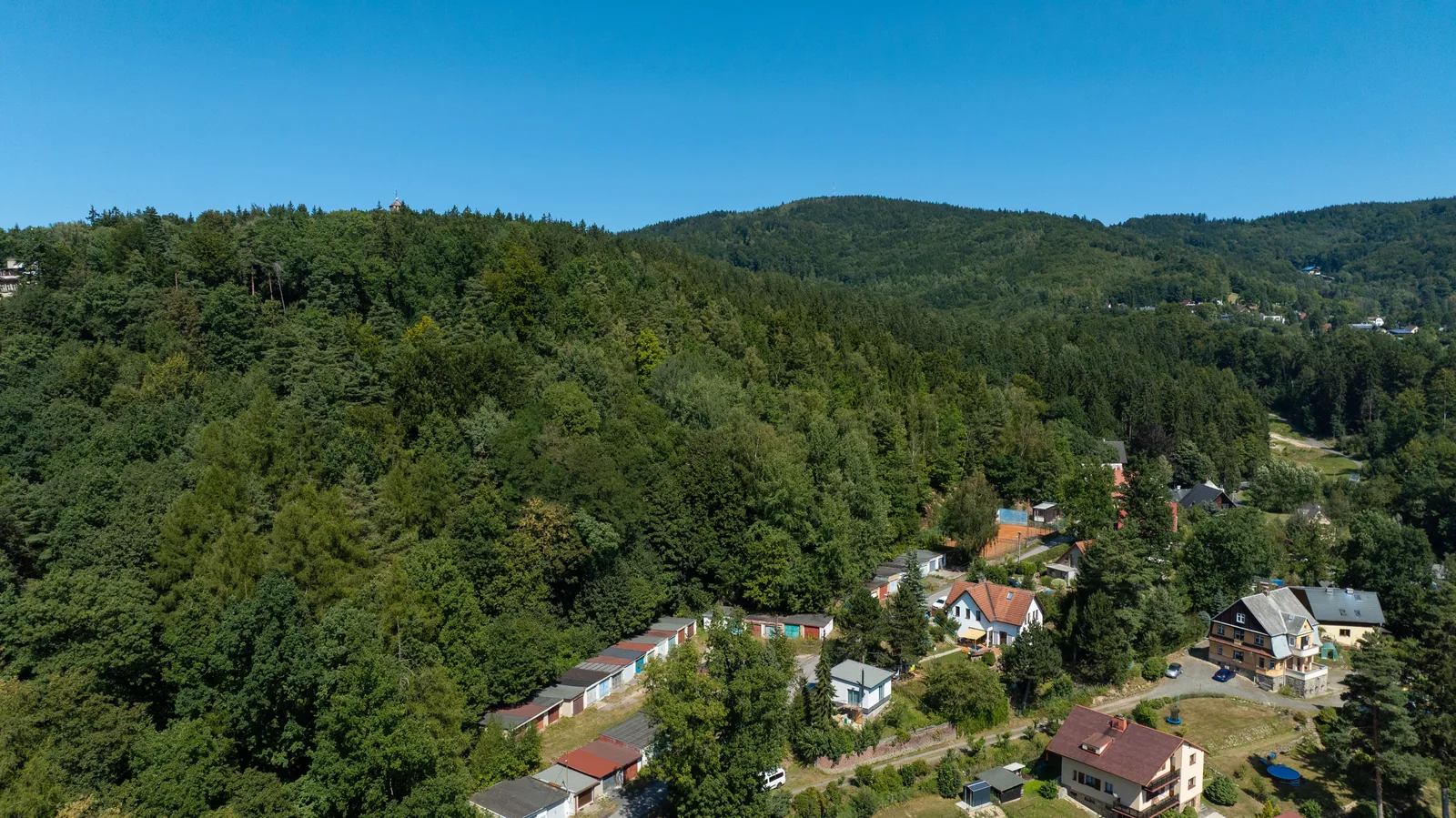 Zalesněný hřeben nad vilovou čtvrtí
