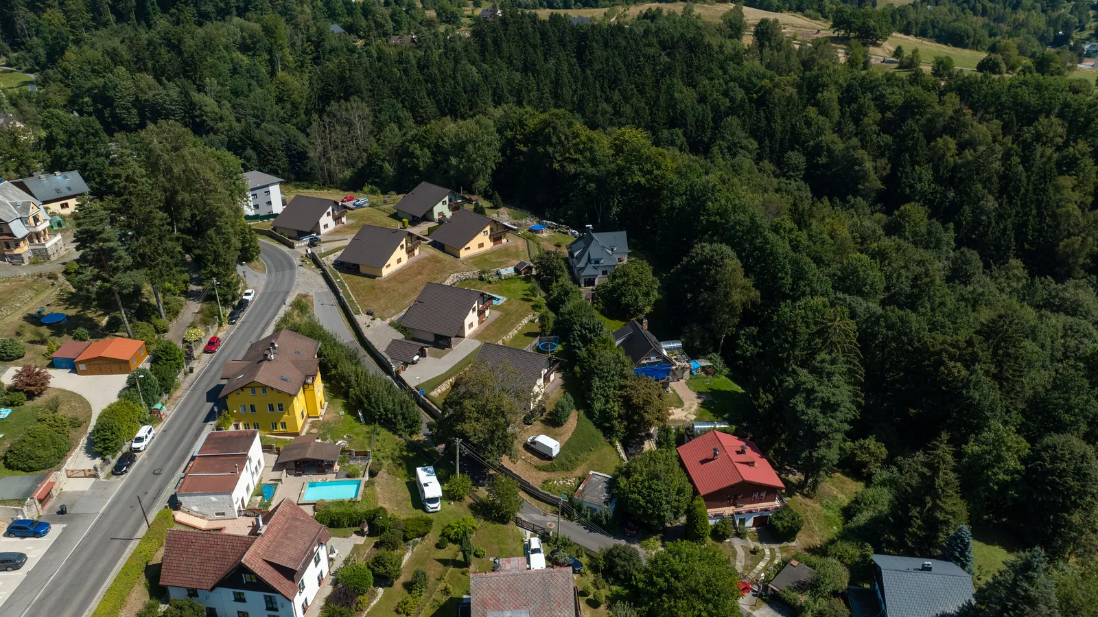 Jizerská ulice stoupající k lesu nad čtvrtí