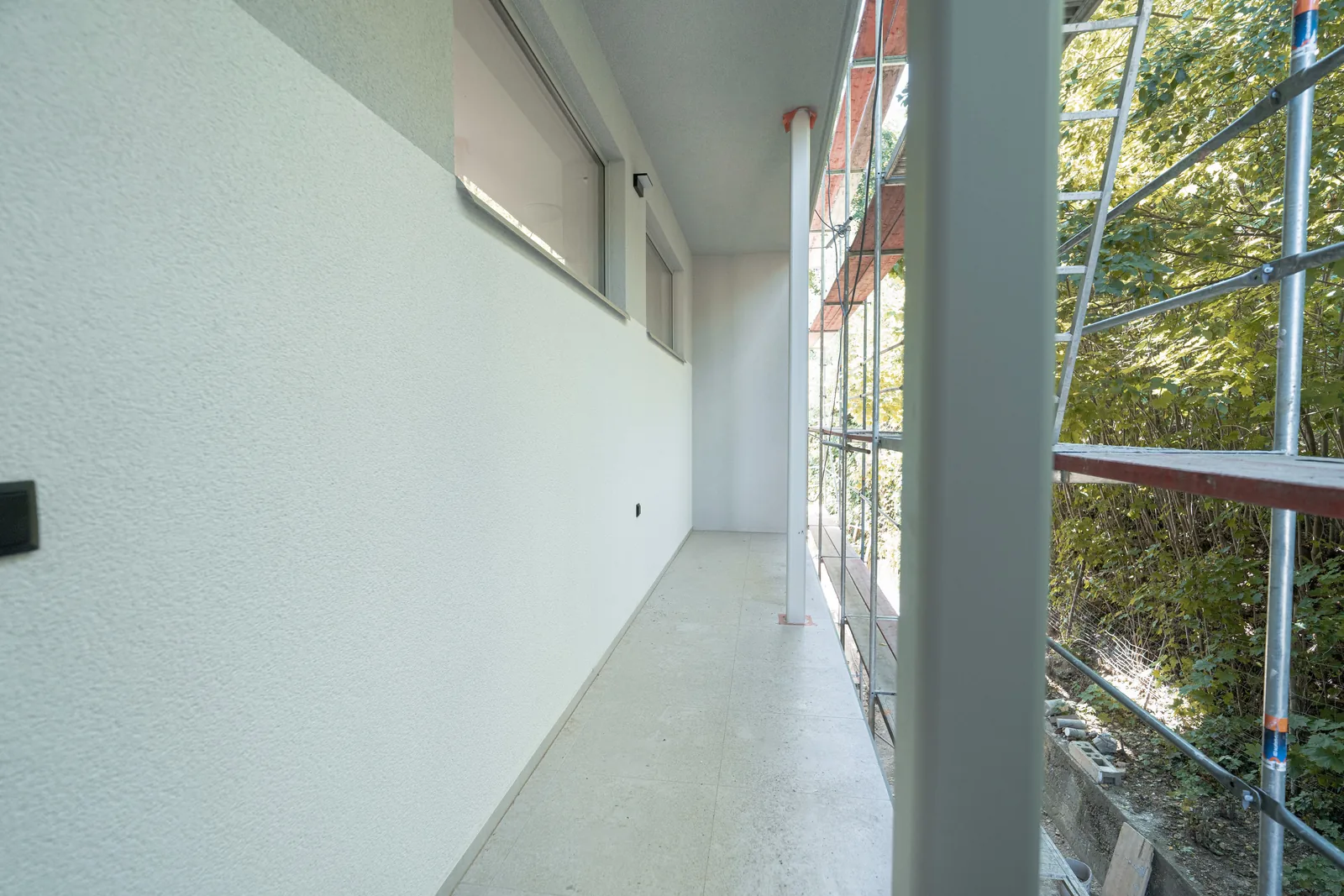 Der Flur der Wohnung mit verglaster Wand ins Grüne