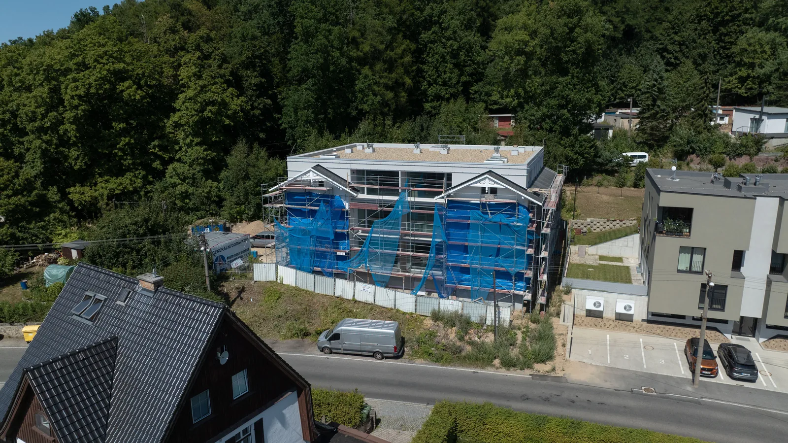 Švýcarská vila am Hang über der Straße, hinter dem Haus der Wald