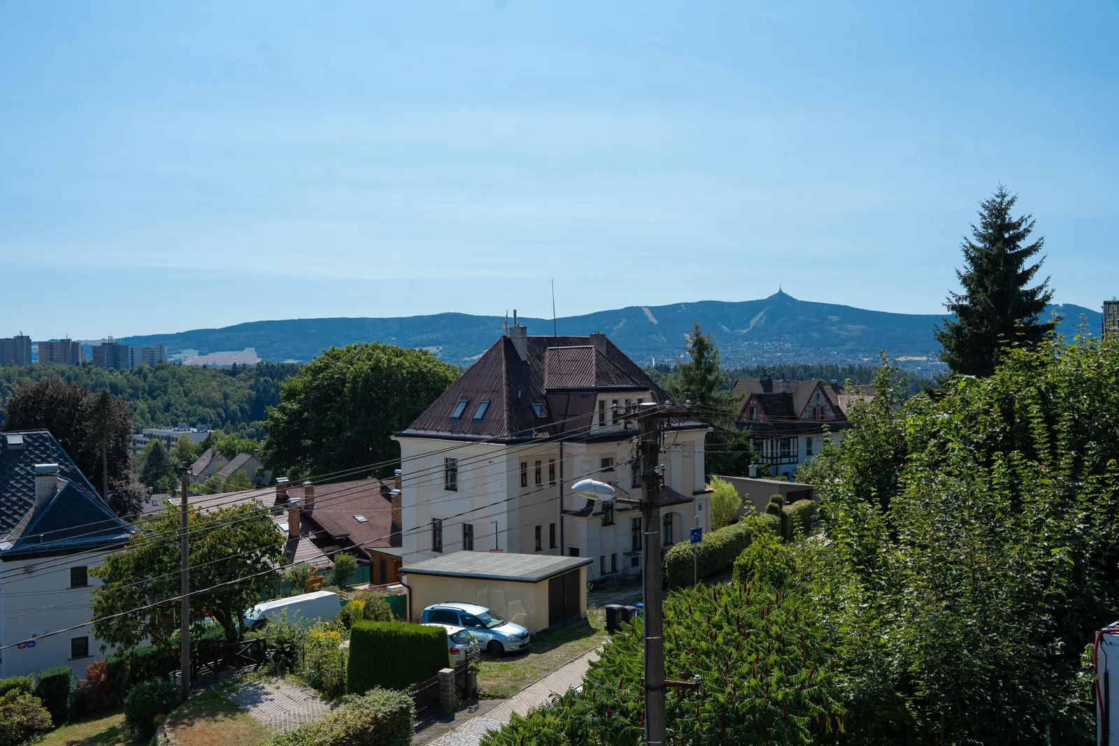 Blick aus einer Wohnung auf die Nachbarvillen und den bewaldeten Kamm über Liberec